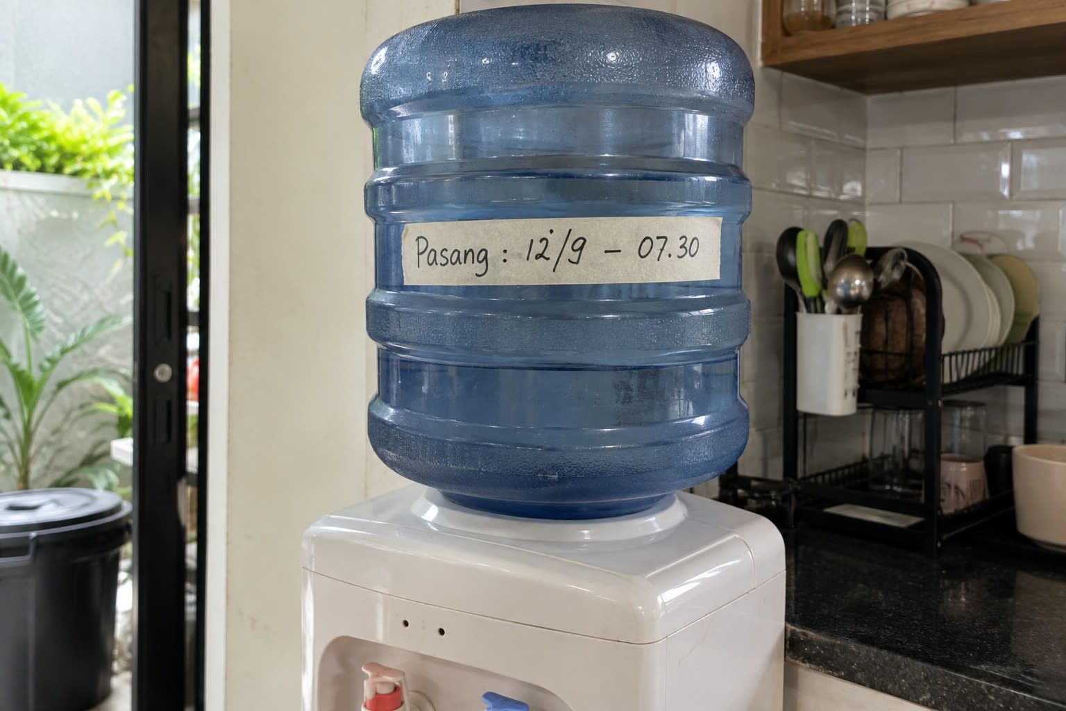 Galon ditandai selotip kertas bertuliskan tanggal dan jam pemasangan. Saat galon habis, selisih waktunya langsung terlihat tanpa perlu mengingat-ingat.